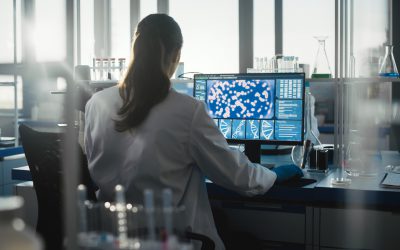 Medical Science Laboratory with Diverse Team of Professional Biotechnology Scientists Developing Drugs, Female Biochemist Working on Computer Showing Gene Therapy Interface. Back view Shot